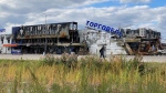 A man walks by a destroyed shopping centre in Bucha, Ukraine, on Sept. 25, 2022. (Karl Ritter / AP)