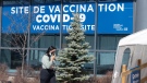 A woman walks past a COVID-19 vaccination clinic, Wednesday, April 6, 2022 in Montreal.THE CANADIAN PRESS/Ryan Remiorz