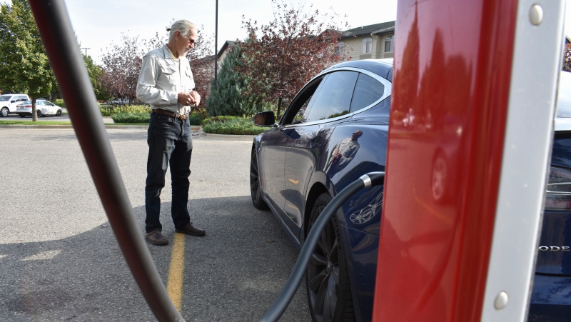 Bob Palrud of Spokane, Wash. speaks with a fellow electric vehicle owner who is charging up at a station along Interstate 90, on Wednesday Sept. 14, 2022, in Billings, Mont. Palrud says distances between EV charging stations are always on his mind during lengthy journeys across the U.S. West where such infrastructure remains sparse. (AP Photo/Matthew Brown)
