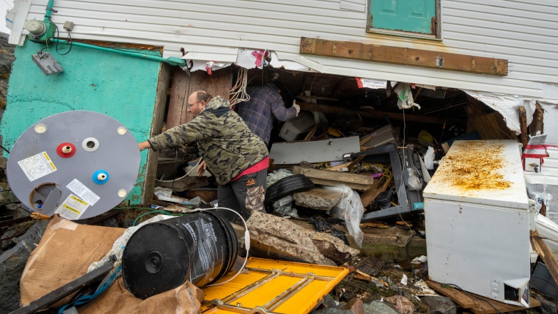 Jamie King clears out the rubble and belongings from the washed out foundation and basement of his house in Burnt Island, Newfoundland and Labrador on Tuesday September 27, 2022. Fiona left a trail of destruction across much of Atlantic Canada, stretching from Nova Scotia's eastern mainland to Cape Breton, Prince Edward Island and southwestern Newfoundland. (Source: THE CANADIAN PRESS/Frank Gunn)