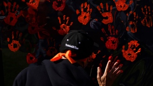 People contribute to a hand painting during the National Day for Truth and Reconciliation in Ottawa on Thursday, Sept. 30, 2021. (Sean Kilpatrick/THE CANADIAN PRESS)