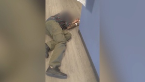 An unknown man, seen lying on the floor of Lethbridge, Alta. health clinic, was taken to hospital by paramedics. (Facebook/David Woods)