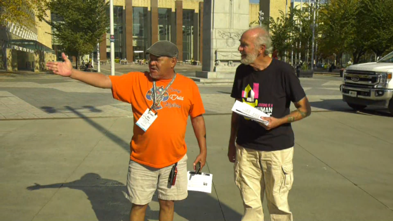 Neil Kennedy (left) and Jim Gurnett are volunteers with the Edmonton Coalition on Housing and Homelessness. They handed out flyers Wednesday encouraging people to pressure governments to support social housing. (CTV News Edmonton/John Hanson) 