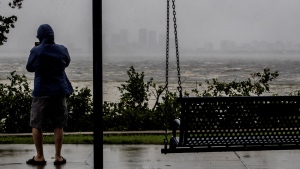 One sightseer witnesses the receding waters of Tampa Bay because of low tide and tremendous winds from Hurricane Ian with downtown in the distance in Tampa, Fla., Wednesday, Sept. 28, 2022. (Willie J. Allen Jr./Orlando Sentinel via AP) 