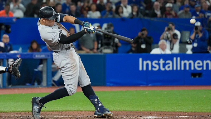New York Yankees designated hitter Aaron Judge (99) hits his 61st home run of the season, a two-run shot, against the Toronto Blue Jays during seventh inning American League MLB baseball action in Toronto on Wednesday, September 28, 2022. THE CANADIAN PRESS/Nathan Denette