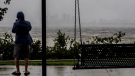 One sightseer witnesses the receding waters of Tampa Bay because of low tide and tremendous winds from Hurricane Ian with downtown in the distance in Tampa, Fla., Wednesday, Sept. 28, 2022. (Willie J. Allen Jr./Orlando Sentinel via AP)