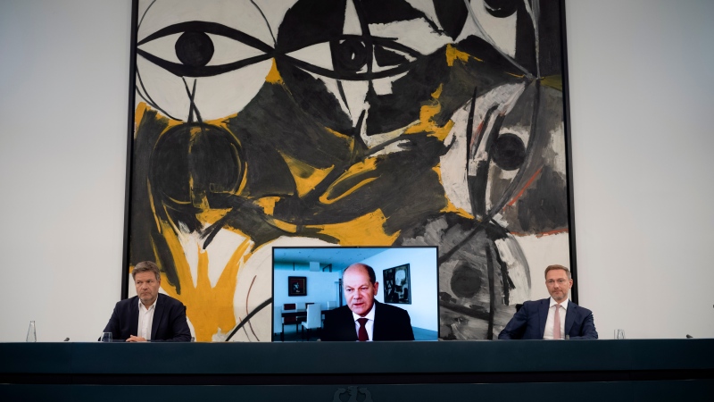 German Chancellor Olaf Scholz, center, Economy and Climate Minister Robert Habeck, left, and Finance Minister Christian Lindner, right, brief the media during a news conference about the energy supply situation in Germany at the chancellery in Berlin, Germany, Thursday, Sept. 29, 2022. Scholz appears via videolink as he is in quarantine for coronavirus. (AP Photo/Markus Schreiber)
