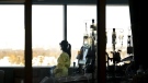 A registered nurse takes a moment to look outside while attending to a ventilated COVID-19 patient in the intensive care unit at the Humber River Hospital during the COVID-19 pandemic in Toronto on January 25, 2022. Nathan Denette / THE CANADIAN PRESS