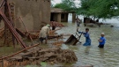 A family salvage usable items from their flood-hit home in Jaffarabad, a district of Pakistan's southwestern Baluchistan province, Thursday, Aug. 25, 2022. (AP Photo/Zahid Hussain)