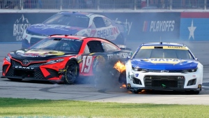 Chase Elliott (9) has his tire catch fire as Martin Truex Jr. (19) and Corey LaJoie (7) drive past during the NASCAR Cup Series auto race at Texas Motor Speedway in Fort Worth, Texas, Sunday, Sept. 25, 2022. (AP Photo/Larry Papke)