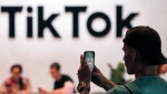 A visitor makes a photo at the TikTok exhibition stands at the Gamescom computer gaming fair in Cologne, Germany, Thursday, Aug. 25, 2022. Around 1,100 exhibitors from 53 countries expect tens of thousands gaming enthusiast daily for the first time since the COVID-19 pandemic at the world's largest gaming event. (AP Photo/Martin Meissner)