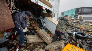 A neighbour helps Jamie King (right) as he clears out the rubble and belongings from the washed out foundation and basement of his house in Burnt Island, Newfoundland and Labrador on Tuesday September 27, 2022. Fiona left a trail of destruction across much of Atlantic Canada, stretching from Nova Scotia's eastern mainland to Cape Breton, Prince Edward Island and southwestern Newfoundland. THE CANADIAN PRESS/Frank Gunn