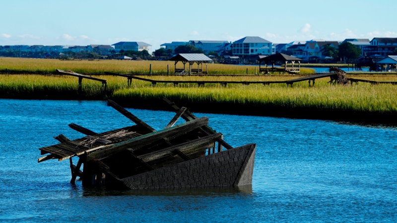 A boat house is overturned in the inlet between Pawleys Island and the mainland following winds and rain from Hurricane Ian on Saturday, Oct. 1, 2022, in Pawleys Island, S.C. (AP Photo/Meg Kinnard)