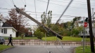 A snapped power pole hangs over a street in New Glasgow, N.S. on Wednesday, September 28, 2022 following significant damage brought by post tropical storm Fiona. THE CANADIAN PRESS/Darren Calabrese