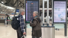 Travellers Paul Peloquin and Linda Johnson aren’t wearing masks as they arrive at Ottawa International Airport, but they are planning to put them on once they board the plane. (Jackie Perez/CTV News Ottawa)