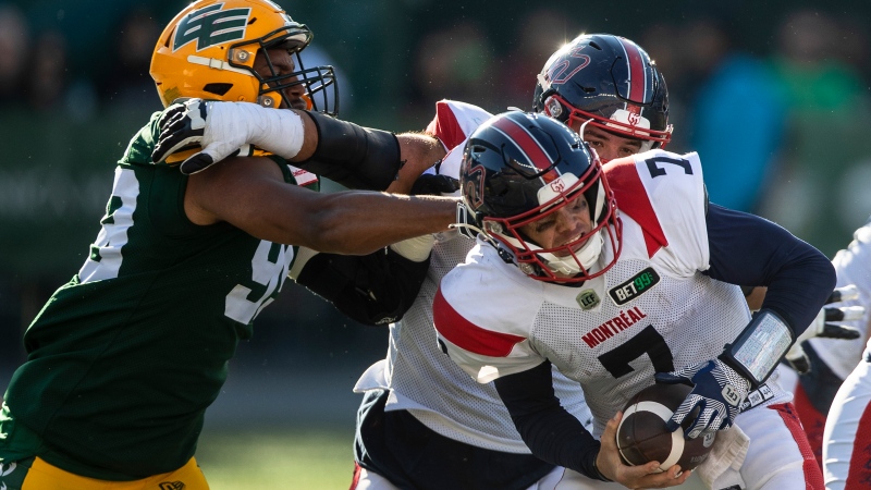 Montreal Alouettes quarterback Trevor Harris (7) is tackled by Edmonton Elks' Christian Rector (99) during second half CFL action in Edmonton, Alta., on Saturday, October 1, 2022 (The Canadian Press/Jason Franson).