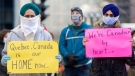 People take part in a demonstration outside Quebec Premier Francois Legault’s office in Montreal, Saturday, Nov. 21, 2020, where they called on the government to give permanent residency status to all migrant workers and asylum seekers.The COVID-19 pandemic continues in Canada and around the world. THE CANADIAN PRESS/Graham Hughes
