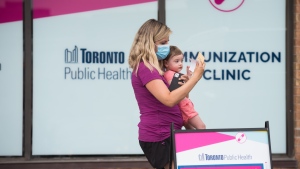 Christina Sibian holds her 13-month-old daughter Alexis Willschick after she received her first COVID-19 vaccine at the Crossroads Plaza immunization clinic at in Toronto, on Thursday, July 28, 2022. THE CANADIAN PRESS/ Tijana Martin