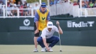 Mackenzie Hughes, of Canada, lines up his putt on the 18th green with his caddie Jace Walker behind him, in a second hole playoff during the final round of the Sanderson Farms Championship golf tournament in Jackson, Miss., Sunday, Oct. 2, 2022. (James Pugh/impact601.com via AP)