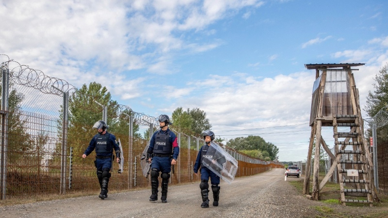 Operational police officers walk along the service route of Hungary's border with Serbia near Roszke, Southern Hungary, Sept. 28, 2022. (Tibor Rosta/MTI via AP, File)