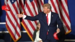 Former U.S. president Donald Trump tosses caps to the crowd as he steps onstage during a rally at the Macomb Community College Sports & Expo Center in Warren, Mich., Saturday, Oct. 1, 2022. (Todd McInturf/Detroit News via AP) 