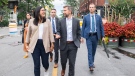 Security personnel walk behind Quebec Solidaire co-spokesperson Gabriel Nadeau-Dubois and local candidate Alejandra Zaga Mendez while on a walkabout during an election campaign stop in the riding of Verdun, Montreal, Sunday, September 4, 2022. Quebecers will go to the polls on October 3rd. THE CANADIAN PRESS/Graham Hughes