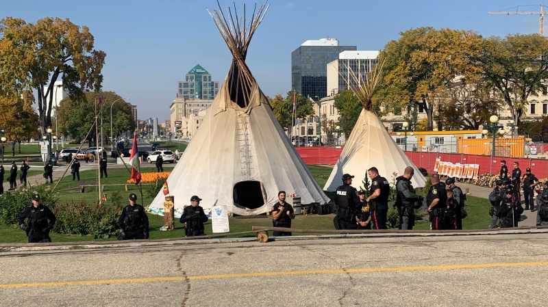 Winnipeg police and Manitoba Conservation officers surround an encampment on the Legislature lawn as it is prepared to be taken down. Oct. 4, 2022. (Source: Scott Andersson/CTV News)