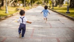 A stock photo shows two young children running and playing together. (Pexels/Caleb Oquendo)