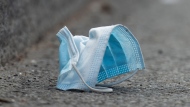 A disposable face mask is shown discarded on a street in Montreal, Sunday, April 18, 2021. THE CANADIAN PRESS/Graham Hughes 
