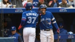 Toronto Blue Jays outfielder Teoscar Hernandez (37) celebrates with teammate George Springer (4) after scoring on a single by catcher Danny Jensen during second inning AL MLB baseball action against the Boston Red Sox in Toronto on Saturday, October 1, 2022. THE CANADIAN PRESS/Christopher Katsarov 