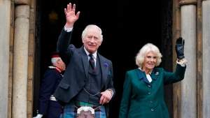 King Charles III and Camilla, the Queen Consort, wave as they leave Dunfermline Abbey, after a visit to mark its 950th anniversary, and after attending a meeting at the City Chambers in Dunfermline, Fife, where the King formally marked the conferral of city status on the former town. (Andrew Milligan/PA via AP)