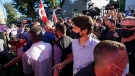 Liberal Leader Justin Trudeau is escorted by his RCMP security detail as protesters shout and throw gravel while leaving a campaign stop at a local micro brewery during the Canadian federal election campaign in London Ont., on Monday, September 6, 2021. THE CANADIAN PRESS/Nathan Denette
