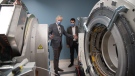 Dr. Jonathan Romsa (left) and Stephen Nelli (right) discuss the mechanics during installation of the positron emission tomography-computed tomography (PET/CT) scanner. (Source: London Health Sciences Centre)