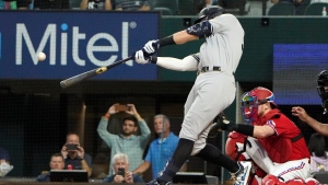 New York Yankees' Aaron Judge hits a solo home run, his 62nd of the season, during the first inning in the second baseball game of a doubleheader against the Texas Rangers in Arlington, Texas, Tuesday, Oct. 4, 2022. With the home run, Judge set the AL record for home runs in a season, passing Roger Maris. (AP Photo/LM Otero)