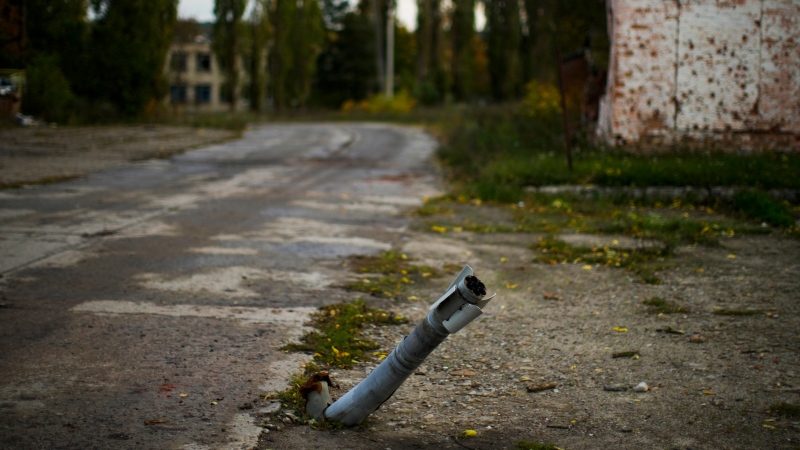 An unexploded Russian rocket sticks out of the road at Staryi-Saltiv village, Ukraine, Wednesday, Oct. 5, 2022.  (AP Photo/Francisco Seco)