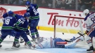 Edmonton Oilers goalie Stuart Skinner, centre, stops Vancouver Canucks' Curtis Lazar (20) during the second period of a pre-season NHL hockey game in Abbotsford, B.C., on Wednesday, October 5, 2022. THE CANADIAN PRESS/Darryl Dyck