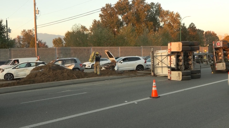 A dump truck flipped at the Vancouver-Burnaby border, spilling dirt all over the road and other vehicles.