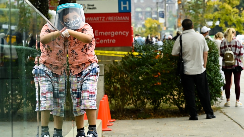 A young boy waits in line at a COVID assessment centre at Mount Sinai Hospital during the COVID-19 pandemic in Toronto on Thursday, September 24, 2020. THE CANADIAN PRESS/Nathan Denette