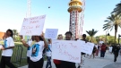 FILE - Family and supporters of Tyre Sampson march and hold signs outside the Orlando Free Fall drop tower ride at ICON Park in Orlando on March 29, 2022. (Stephen M. Dowell/Orlando Sentinel via AP, File)