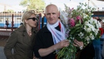 Belarusian human rights advocate Ales Bialiatski, right, is greeted by his wife Natalya Pinchuk, at a railway terminal in Minsk, Belarus, Saturday, June 21, 2014. On Friday, Oct. 7, 2022 the Nobel Peace Prize was awarded to jailed Belarus rights activist Ales Bialiatski, the Russian group Memorial and the Ukrainian organization Center for Civil Liberties. (AP Photo/Dmitry Brushko, File)