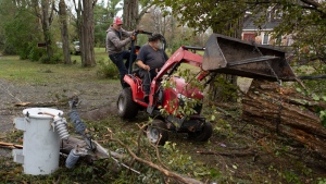 Joey Corbin, left, and Wayne Deyoung use a tractor to clear felled trees near Lower Barneys River in Pictou County, N.S. on Wednesday, September 28, 2022 following significant damage brought by post tropical storm Fiona. THE CANADIAN PRESS/Darren Calabrese 