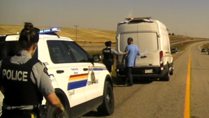 RCMP members speak with a driver during an investigation on the Trans-Canada Highway west of Strathmore n Oct. 1. RCMP officials say the van was stolen, the driver had a suspended licence and he had been drinking. (supplied)