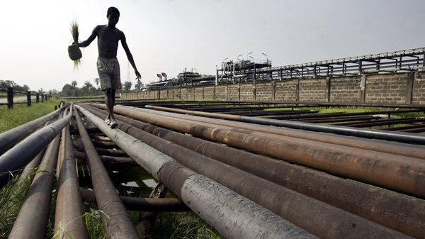 An unidentified youth walk on an oil pipeline in Idu Ogba, Niger Delta area of Nigeria, on Wednesday, Feb. 1, 2006. (AP / George Osodi)