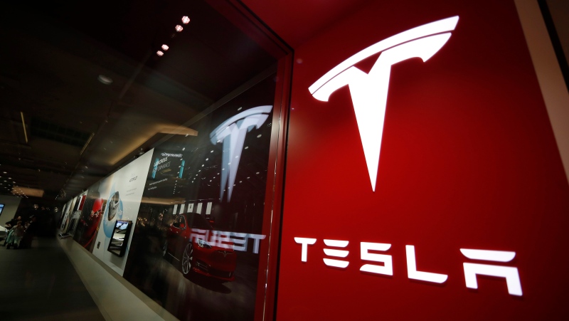 In this Feb. 9, 2019 file photo, a sign bearing the company logo is displayed outside a Tesla store in Cherry Creek Mall in Denver. (AP Photo/David Zalubowski, File)