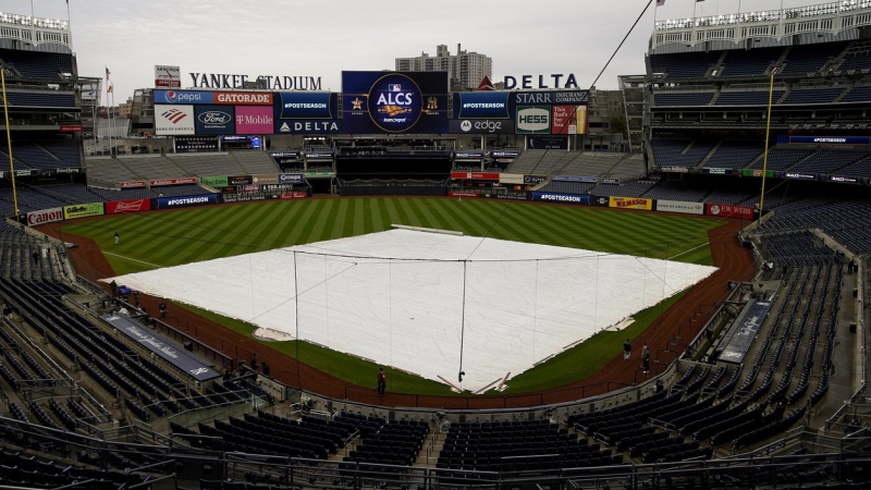 The rain tarp covers the field as a light rain falls on Yankee Stadium before Game 4 of an American League Championship baseball series between the New York Yankees and the Houston Astros, Sunday, Oct. 23, 2022, in New York. (AP Photo/Julia Nikhinson)