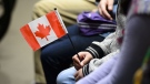 A young new Canadian holds a flag as she takes part in a citizenship ceremony on Parliament Hill in Ottawa on Wednesday, April 17, 2019, to mark the 37th anniversary of the Canadian Charter of Rights and Freedoms. Since the global onset of COVID-19, Canada has been gradually closing the gap with the United States when it comes to attracting and keeping an important economic prize: new permanent residents. THE CANADIAN PRESS/Sean Kilpatrick
