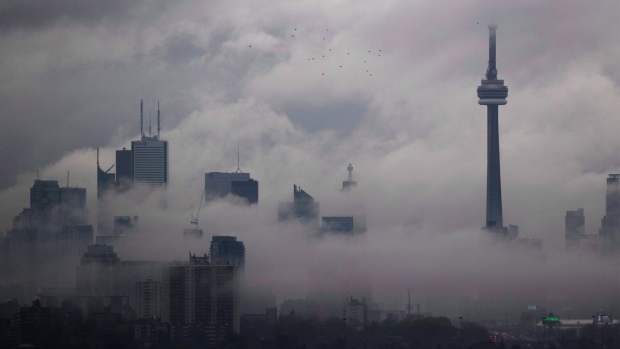Fog rolls in front of the CN Tower and skyline in Toronto, Friday May 13, 2016. THE CANADIAN PRESS/Mark Blinch