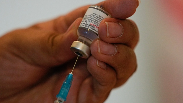 A health-care worker prepares a dose of the COVID-19 bivalent booster at the start of a vaccination campaign for people 80 years and older, in Santiago, Chile, on Oct. 26, 2022. (AP Photo/Esteban Felix)