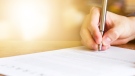 A person signs a document in this undated stock image. (Credit: Shutterstock)