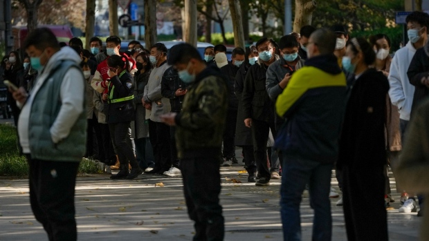 People wearing face masks stand in line for their routine COVID-19 tests at a coronavirus testing site in Beijing, on Nov. 15, 2022. (Andy Wong / AP) 